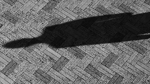 A shadow cast over the pavement